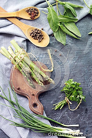 Spicy herbs, asparagus, seasonings, lentils on the kitchen table for preparing healthy homemade food Stock Photo