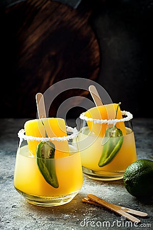 Spicy mango popsicle margarita cocktail with jalapeno and lime. Mexican alcoholic drink for Cinco de mayo party. Stock Photo