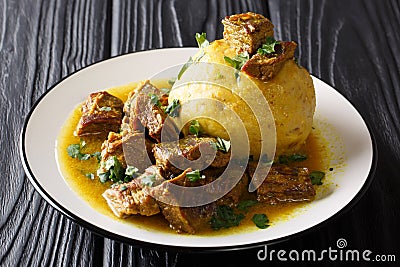 Spicy mofongo with plantains, garlic and chicharron served with meat and broth close-up on the table. horizontal Stock Photo