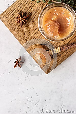 Spicy pear jam in glass jar, fresh pears, spices cinnamon and anise and thyme. Stock Photo