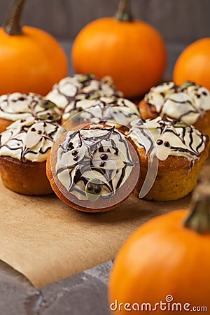 Spicy pumpkin muffins decorated ghosts, spiderweb for Halloween celebration. Autumn composition with pumpkins, cupcakes on dark Stock Photo