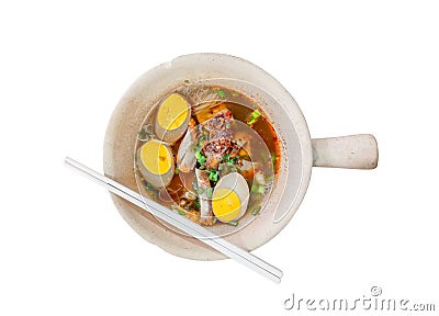 Spicy roll noodle brown broth soup with slice boiled eggs, liver, crispy pork, bean sprouts, green onion leaf, cayenne pepper Stock Photo
