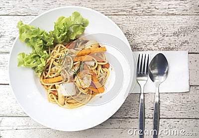 Spicy spaghetti with Tom Yum Seafood on wood table Stock Photo