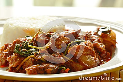 Spicy stir fried grilled pork curry with herb eat couple with rice on plate Stock Photo