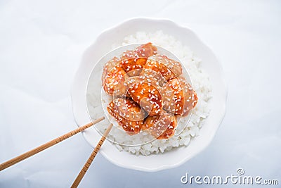 Spicy sweet and sour chicken with sesame and rice on white background top view Stock Photo