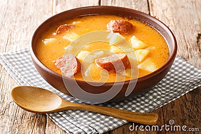 Spicy thick potato soup with sausages and sour cream close-up in a plate. horizontal Stock Photo