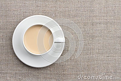Spicy warming tea with milk in white porcelain cup on textile background Stock Photo