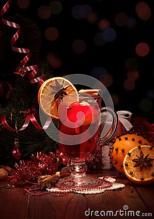 Spicy warming winter drink in glass, fruit and spices, New Year` Stock Photo