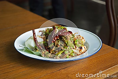 Spicy Winged bean salad with shrimp and boiled egg in white dish on wooden table. Thai food call Stock Photo