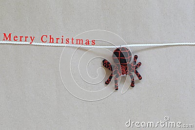 Spider doll artificial hanging on a rope and have merry christmas text. Stock Photo