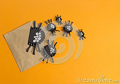 Spiders from paper crawl out of the envelope. Orange background. Stock Photo