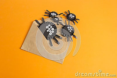 Spiders from paper crawl out of the envelope. Orange background. Stock Photo