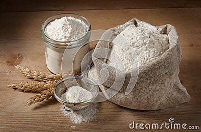 Spikelets and flour in the bag, jar on the boards Stock Photo