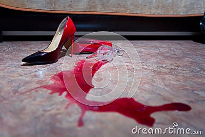 A spilled glass of wine and women`s shoes on the floor Stock Photo