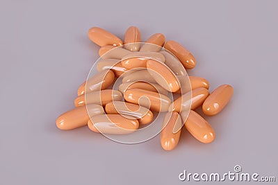 Spilled orange capsules on the white background. Stock Photo