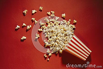 Spilled popcorn on a red background, cinema, movies and entertai Stock Photo