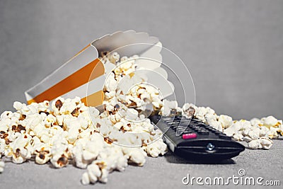 Spilled popcorn and remote control ready for television watching and streaming service on the sofa at home Stock Photo