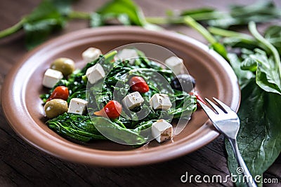 Spinach with cheese, olives and pepper drops Stock Photo