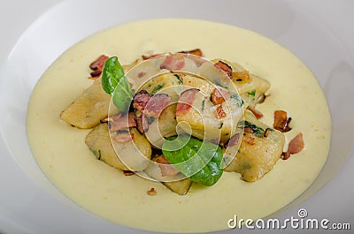 Spinach gnocchi with parmesan sauce topped with bacon Stock Photo