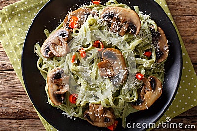 Spinach noodles with mushrooms and parmesan cheese close-up. Horizontal top view Stock Photo
