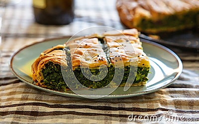 Spinach pie or greek spanakopita serving on kitchen table Stock Photo