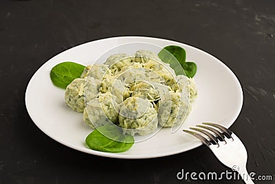 Spinacj and cheese gnocchi on white plate with fork Stock Photo