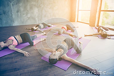 Spinal twist. Five young sport women are stretching in modern st Stock Photo