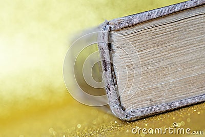 The spine of a thick old book lying on a yellow golden background. Library archive. History and memoirs. Literature and philology Stock Photo