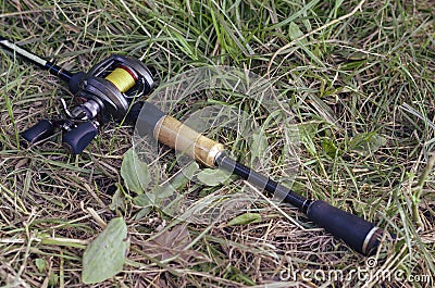 Spinning with a casting reel lies in the grass on the river bank Stock Photo