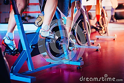 Spinning class, group activity on stationary bike. Team cardio excercise on bicycle. Stock Photo