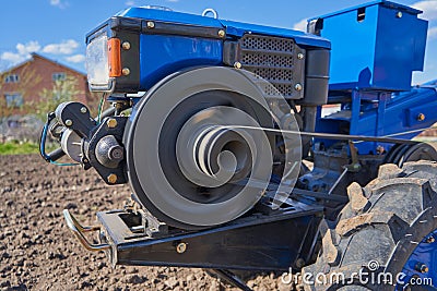 Spinning tractor flywheel,the work of the engine of a two-wheeled tractor in the field, the work of the flywheel Stock Photo