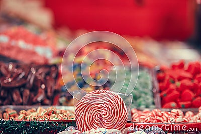 Spiral lolipop surrounded by colorful candy blur Stock Photo