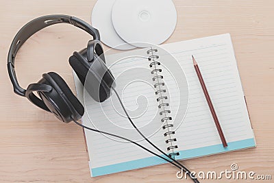 Spiral notebook and headphone on wood background Stock Photo