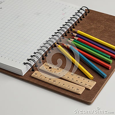 Spiral notebook open to a graph paper page, with colorful pencils neatly arranged Stock Photo