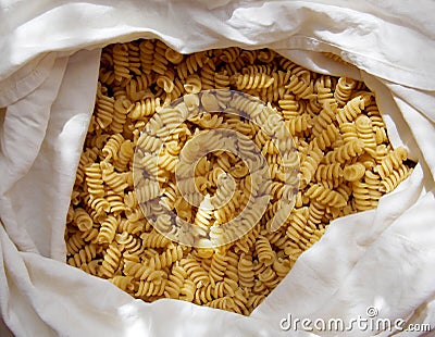 Spiral yellow pasta in a white fabric bag Stock Photo