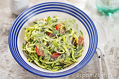 Spiralled courgette with green pesto and cherry tomatoes Stock Photo
