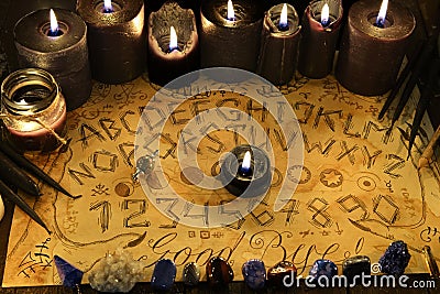 Spiritual magic board with alphabet and numbers, and with black candles Stock Photo