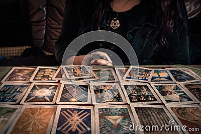 Spiritual wicca witch reading occult mystic old tarot cards laying on table for a magical pagan ritual psychic destiny reading Stock Photo