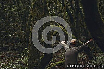 Spiritual zenlike nature love people. One man with closed eyes and outstretching arms in the nature forest green trees scenic Stock Photo