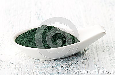 Spirulina powder in white porcelain spoon Stock Photo