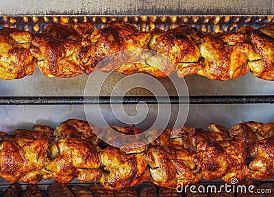 Spit-roasted rotisserie chickens under gas flame Stock Photo