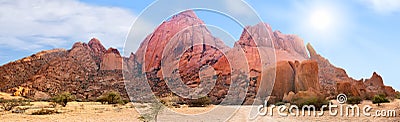 Spitzkoppe mountains range panoramic view on blue sky, clouds and bright sun background, mountain panorama landscape, Namibia Stock Photo