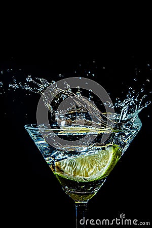 splash in a glass with lime slice on a black Stock Photo