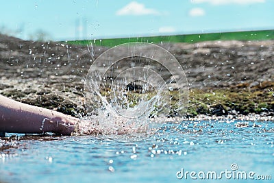 Splash hands in a puddle. a female hand clapping in a puddle Stock Photo