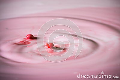 Splash of milk drop in pink color. Stock Photo