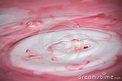 Splash of milk drop in pink color. Stock Photo