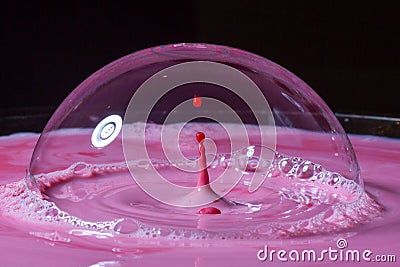 Splash of milk drop in pink color under the buble. Stock Photo