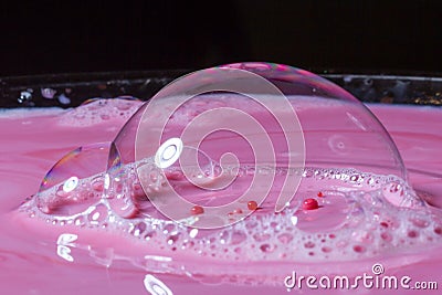 Splash of milk drop in pink color under the buble. Stock Photo