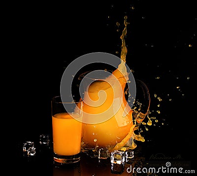 Splash in orange juice in a transparent jug on a black backgroun Stock Photo