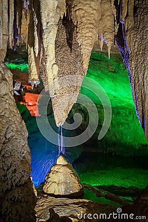 Splashes of water from a stalactite creating a stalagmite beneath it in a cave. Stock Photo
